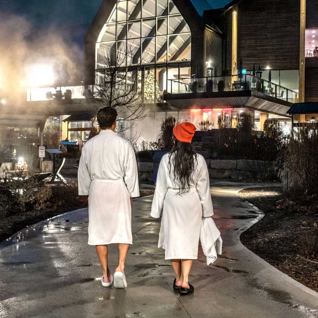 A couple walking towards the Vetta Nordic Spa building